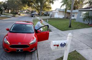 Nevin Overmiller, 78, walks a KFC food delivery to a customers door while delivering for Uber Eats, Wednesday, Jan 5, 2021, in Palm Harbor, Fla. Attacks which occurred in Florida last month sent ripples of fear among some app-based drivers, who have long demanded better protection from companies whose safety policies they say are bettered geared toward customers than workers. (Douglas R. Clifford / Tampa Bay Times)