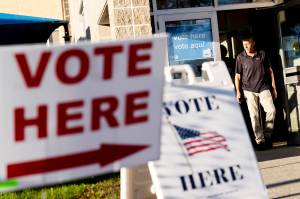 Signs point to the entrance on the last day of early voting before the midterm election as a man walks out of a polling site in Cranston, R.I., on Nov. 7, 2022. Almost half of all voters in the 2022 midterm elections cast their ballots before Election Day either by mail or through early voting, with Asian and Hispanic voters leading the way, new data from the U.S. Census Bureau released Tuesday, May 2, 2023, shows, even as Republican-led states have tightened rules on voting by mail. (AP Photo / David Goldman)