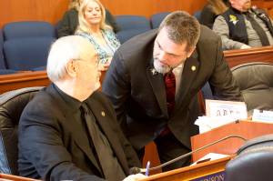State Rep. Mike Cronk, R-Tok, left, confers with Rep. Craig Johnson, during floor debate Wednesday about a bill prohibiting state and local governments from imposing firearms restrictions during disaster declarations. (Mark Sabbatini / Juneau Empire)