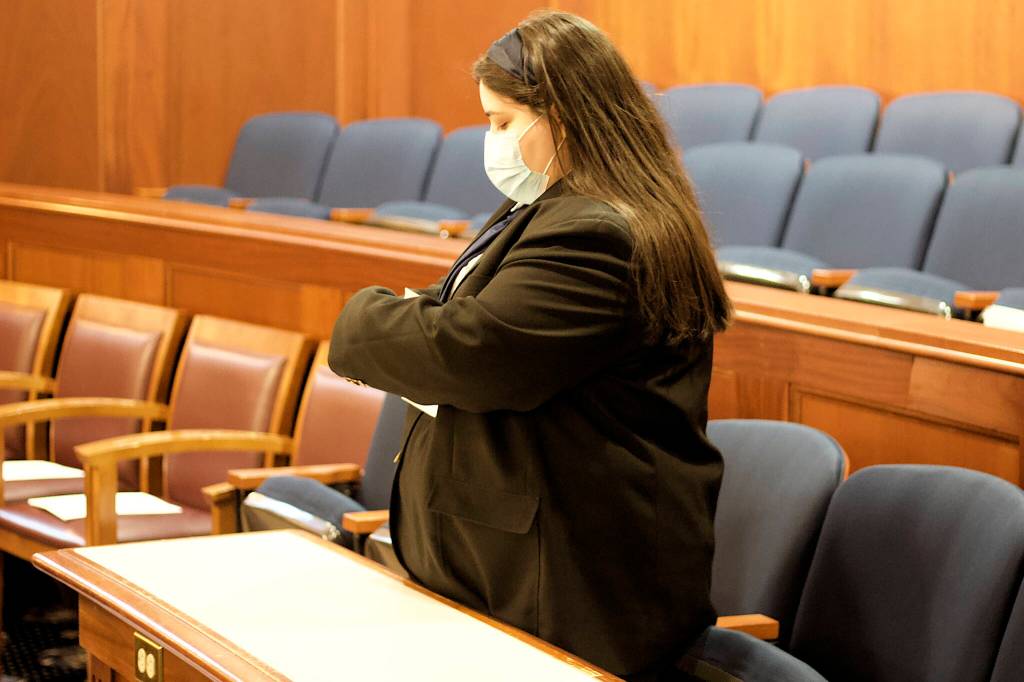 Elena-Kenatsú Truitt, a House page, puts paperwork on chairs at the rear of the House chamber in preparation for Senators who will be attending a joint session of the Legislature on Tuesday to vote on Gov. Mike Dunleavys nominees to dozens of state positions. (Mark Sabbatini / Juneau Empire)