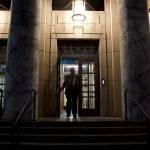 A legislative staff member leaves the Alaska State Capitol late Monday night after the House Finance Committee took a series of actions on bill aimed at resolving differences with the Senate in order to adjourn the regulation session by its Wednesday deadline. (Mark Sabbatini / Juneau Empire)