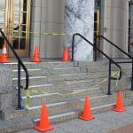 A person entering the Alaska State Capitol on Wednesday morning looks at reflective anti-slip strips being installed on the stairs. The entrance stairs of the 82-year-old building are slippery when wet or icy, and the initial weeks of the legislature session occur when Juneau is experiencing long hours of darkness. (Mark Sabbatini / Juneau Empire)