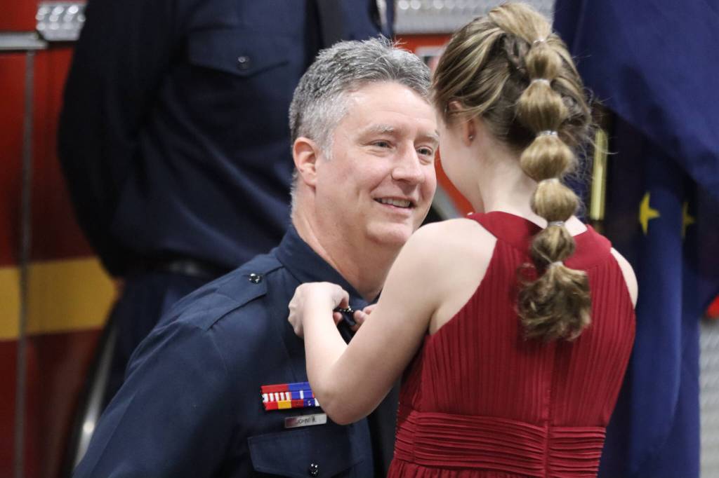 CCFR Captain John Adams youngest daughter Morgan attaches a pin to his lapel during his badge pinning ceremony at Station 1 on Thursday. Adams was also joined by his eldest daughter Raegan and his wife Jennifer. (Jonson Kuhn / Juneau Empire)