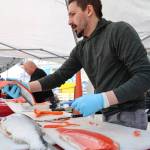 Jared Jerabek with Alaska Glacier Seafood fillets sockeye salmon to be cooked and handed out for free by Taku Smokeries during 2023 Juneau Maritime Festival Saturday afternoon at the Elizabeth Peratrovich Plaza. (Clarise Larson / Juneau Empire)
