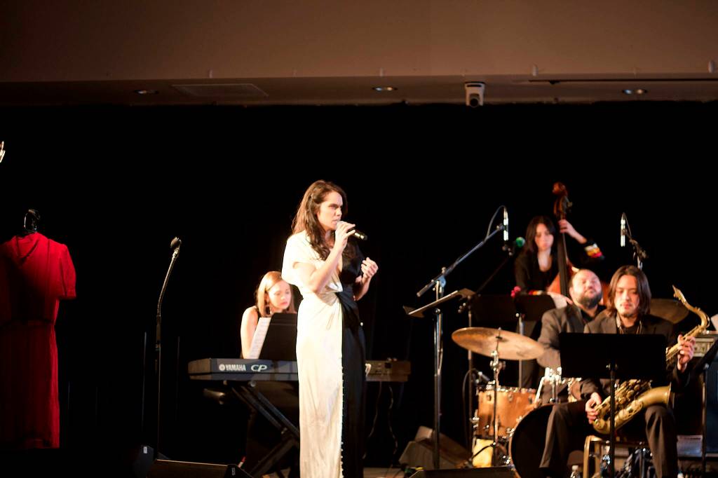 A red dress hanging at one end of the stage serves as recognition of the National Day of Awareness for Missing and Murdered Indigenous Women and Girls during a concert by the Julia Keefe Indigenous Big Band on Friday night at Elizabeth Peratrovich Hall. (Mark Sabbatini / Juneau Empire)