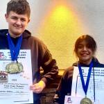 Darren Foster and Nixie Schooler with some of their gold medals and their prestigious Triple Crown belt buckles at the USA Wrestling Alaska State Championships at the Menard Center in Wasilla from May 3-7. (Courtesy Photo / Jason Hass)