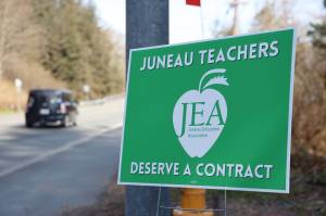 A car drives past a Juneau Education Association sign posted next to the North Douglas Highway in early May. On Friday the Juneau District Board of Education voted to accept a three-year contract agreement with Juneau Education Association, which OKd the contract earlier in the week. (Clarise Larson / Juneau Empire)