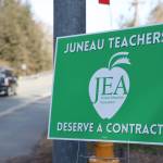 A car drives past a Juneau Education Association sign posted next to the North Douglas Highway in early May. On Friday the Juneau District Board of Education voted to accept a three-year contract agreement with Juneau Education Association, which OKd the contract earlier in the week. (Clarise Larson / Juneau Empire)