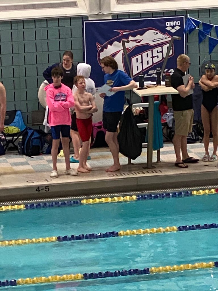 Andrew Sanders and Liam Kiessling speaking to Glacier Swim Club coach Josiah Loseby after a race at this years Alaska Swimming State Championship in Anchorage. (Courtesy Photo / Savona Kiessling)