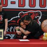 JDHS assistant coach Nicole Fenumiai hugs JDHS senior Kiyara Miller as JDHS head coach Tanya Nizich looks on during Millers letter of intent signing on Wednesday to play basketball at Peninsula College. (Klas Stolpe / Juneau Empire)