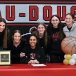 JDHS teammates pose with Kiyara Miller on Wednesday after she signed to play basketball at Peninsula College. From left: Mila Hargrave, Rayna Tuckwood, Miller, Tatum Billings, Chloe Casperson, Carlynn Casperson and Ashley Laudert. (Klas Stolpe / Juneau Empire)