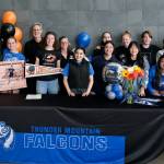 Mackenzie Olver is joined by members of the local soccer community after signing a national letter of intent on Thursday in the Thunder Mountain commons, to play soccer and study at Lewis & Clark College in Portland, Oregon. (Klas Stolpe / Juneau Empire)