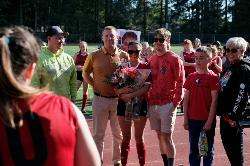 JDHS senior Mariah Kadinger poses with family for a photo during the Crimson Bears girls soccer senior recognition at the Adair-Kennedy pitch Tuesday. (Klas Stolpe / Juneau Empire)