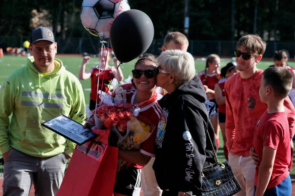 JDHS senior Mariah Kadinger receives a kiss during the Crimson Bears girls soccer senior recognition at the Adair-Kennedy pitch Tuesday. (Klas Stolpe / Juneau Empire)