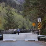 People walk along the Basin Road Trestle Tuesday evening as concrete barricades block off its entrance. The trestle is set to close to pedestrian traffic spanning from May 26 to June 11 between 7 a.m. and 7 p.m. while a contracted construction company repairs damages the trestle suffered in January from a rockslide. (Clarise Larson / Juneau Empire)
