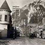 By 1914 when this photo was taken, Juneau had developed into an established city. The Victorian era turreted Alaska Steam Laundry (built 1901) is seen on the left, while other buildings such as the Alaskan Hotel and Central Rooming House are on the right. The rooming house was reconstructed in the 1980s. It is now the Senate Mall. (Alaska State Library-P31-021).