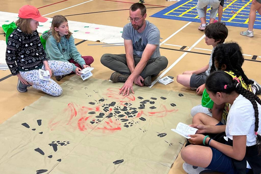 Joel Bos from Discovery Southeast doing an Animal Tracking activity with students from Sayéik: Gastineau Community School during Thursdays STEAM event. (Jonson Kuhn / Juneau Empire)