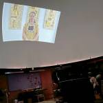 Tlingit weaver and storyteller Lily Hope tells the story of Raven and the Box of Daylight through recorded segments shown on the projector screen at the Marie Drake Planetarium on Friday for the final student field trip of the year. (Jonson Kuhn / Juneau Empire)