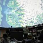 Volunteer Educator Rosemary Walling shows a group of Montessori Borealis first through third graders images of the Earth on Friday at the Marie Drake Planetarium as part of a special presentation of the story of Raven and the Box of Daylight. (Jonson Kuhn / Juneau Empire)