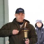 Alaska State Troopers Sgt. Chris Russell lights the torch before the the Alaska Law Enforcement Torch Run began at Twin Lakes Park Saturday morning. (Clarise Larson / Juneau Empire)