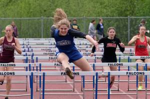 Thunder Mountain High School senior Mallory Welling leads the field en route to winning the girls 100 meter hurdles during the Region V Track & Field Championships, Saturday, at TMHS. From left: Ketchikan junior Linnea Loretan, Welling, Juneau-Douglas junior Hannah Brennell and JDHS freshman Isabella Reyes-Boyer. (Klas Stolpe / Juneau Empire)