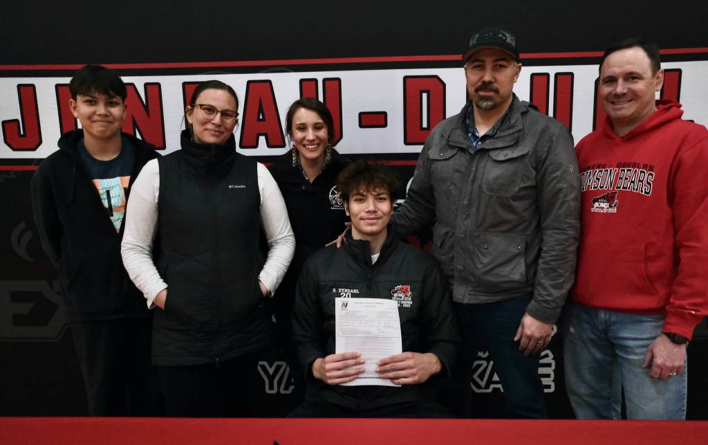 Juneau-Douglas High School: Yadaa.at Kalé Crimson Bears senior center Orion Dybdahl, seated, poses with brother Eli Dybdahl, mother Sarah Dybdahl, sister Michaela Demmert, father Travis Dybdahl and JDHS coach Robert Casperson after signing to play basketball at Centralia College. (Klas Stolpe / Juneau Empire)