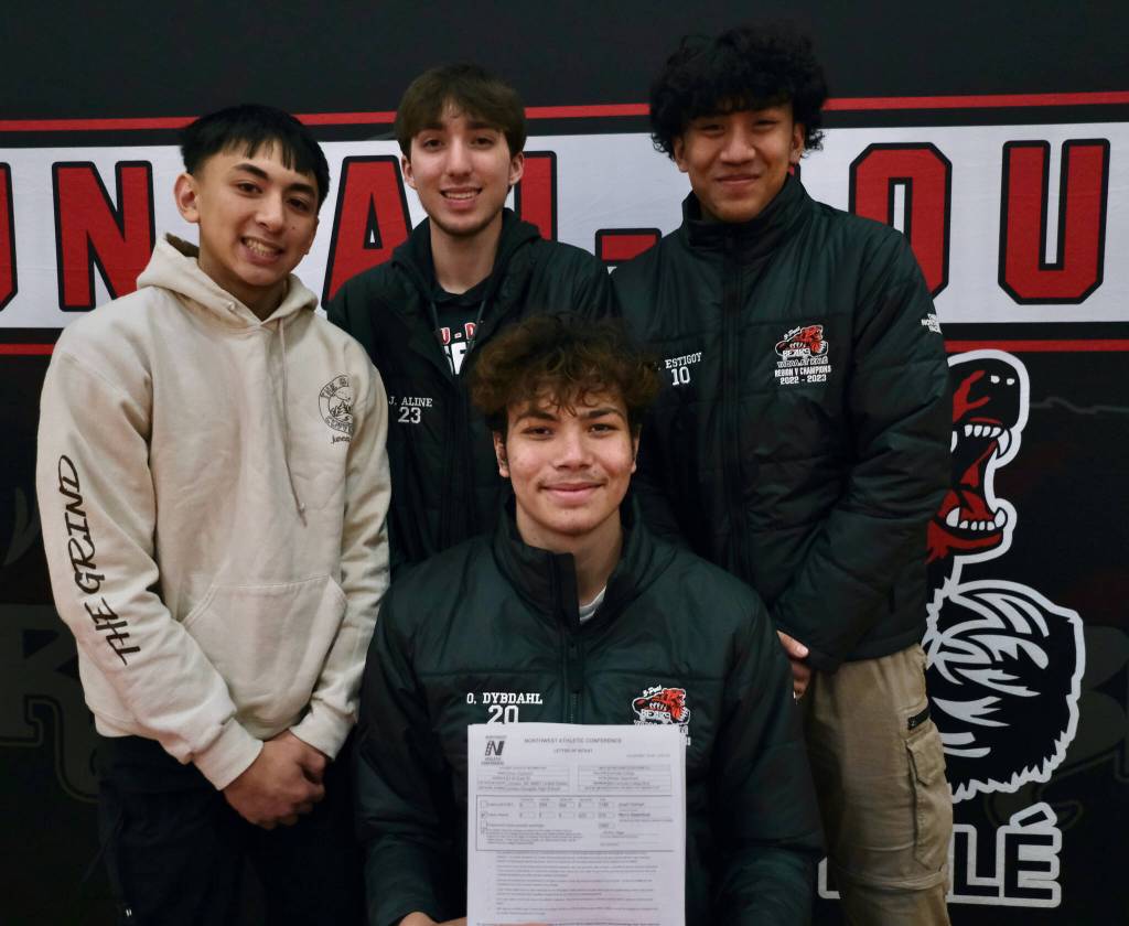 Juneau-Douglas High School: Yadaa.at Kalé Crimson Bears senior center Orion Dybdahl, seated, and teammates Alwen Carrillo, Joey Aline and Jhowel Estigoy at Dybdahls signing to play basketball for Centralia College. (Klas Stolpe / Juneau Empire)