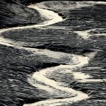 A channel flows through the mud flats along the Seward Highway and Turnagain Arm in Alaska on Oct. 25, 2014. Authorities said, a 20-year-old man from Illinois who was walking Sunday evening, May 21, 2023, on tidal mud flats with friends in an Alaska estuary, got stuck up to his waist in the quicksand-like silt and drowned as the tide came in before frantic rescuers could extract him.  (Bob Hallinen / Anchorage Daily News)