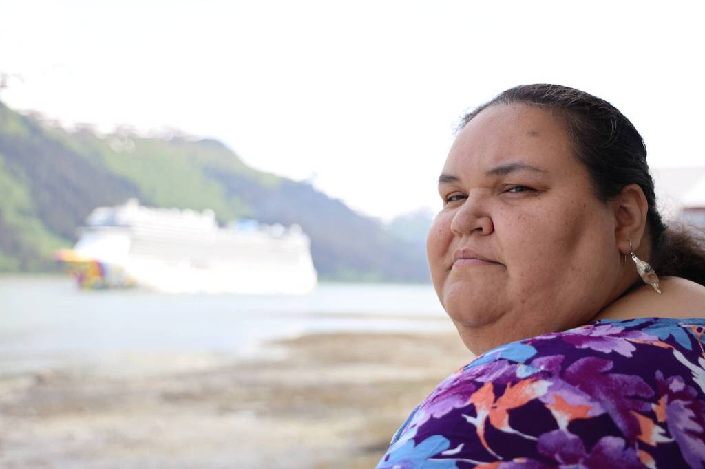 Award-winning Juneau writer Vera Starbard stands on her balcony on Douglas Island that displays banners across Gastineau Channel in support of the Writers Guild of America union strike currently going on across Hollywood and the country. (Clarise Larson / Juneau Empire)