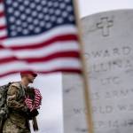 A member of the 3rd U.S. Infantry Regiment, also known as The Old Guard, places flags in front of each headstone for Flags-In at Arlington National Cemetery in Arlington, Thursday, May 25, 2023, to honor the Nations fallen military heroes ahead of Memorial Day. (AP Photo / Andrew Harnik)