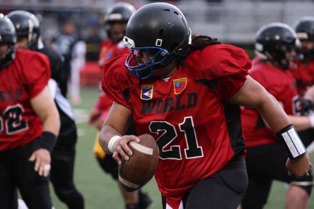 Team Worlds Mika Iputi (21), American Samoa Class of 2010, scrambles after facing pressure during the 2023 Alumni Game at Adair-Kennedy Memorial Field. This years alumni game was played between Team Juneau and Team World. (Ben Hohenstatt / Juneau Empire)