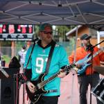 Sean Purvis-Carey rocks out alongside Father Figure bandmates Kyle Bischoff, Brandon Hard and Johnny Perrin during a half-time performance at the Juneau Alumni Football game on Friday at Adair-Kennedy Memorial Park. (Clarise Larson / Juneau Empire)