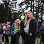 Michaela Meneoza (left) and Anne Coogan (right) smile before launching their paper airplanes during a half-time contest at the Juneau Alumni Football game Friday evening at Adair-Kennedy Field. (Clarise Larson / Juneau Empire)