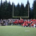 Team World and Team Juneau join together for a photo after the Juneau Alumni Football game Friday evening at Adair-Kennedy Field. (Clarise Larson / Juneau Empire)