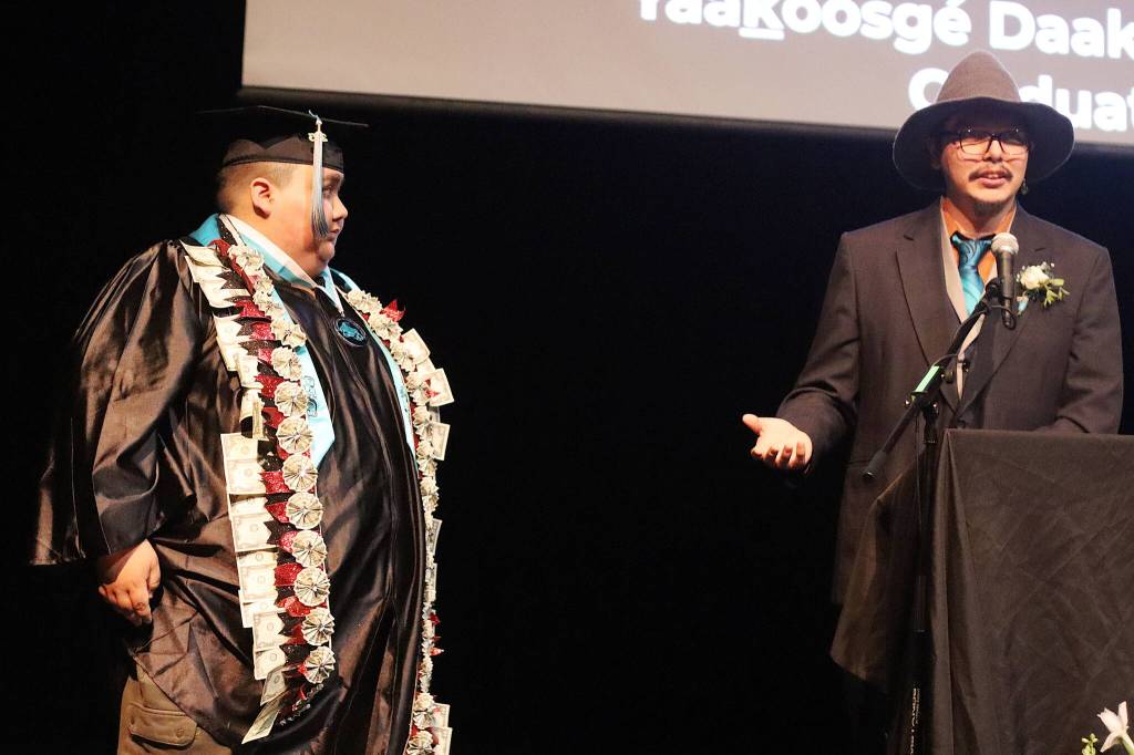 Charles McKenry, a teacher and adviser at Yaakoosgé Daakahídi High School, offers congratulations to senior John Hawkins during the alternative schools graduation ceremony Sunday. (Mark Sabbatini / Juneau Empire)