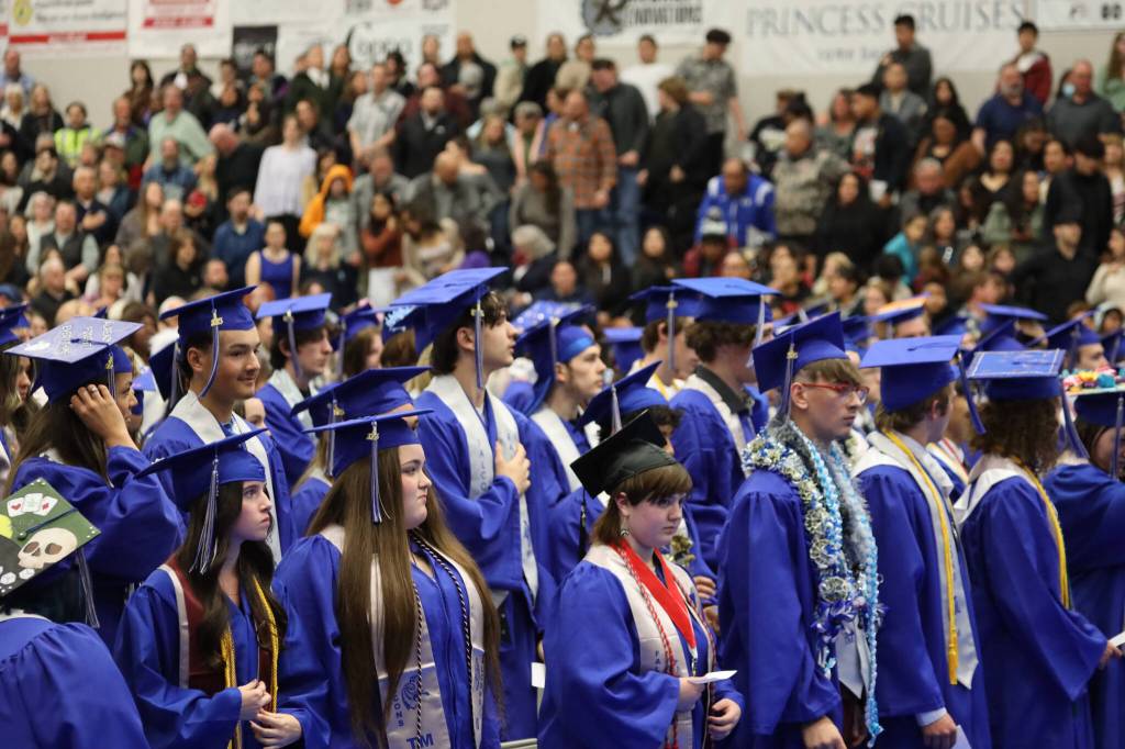 Students stand as they wait to move their tassles during the Thunder Mountain High School 2023 graduation ceremony Sunday afternoon. (Clarise Larson / Juneau Empire)