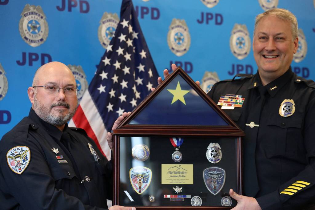 Retiring Juneau Police Department Officer Don Ward (left) and Deputy Chief David Campbell (right) smile for a picture at Wards joint retirement ceremony alongside Officer Jim Esbenshade on Tuesday afternoon at the Juneau Police Station. (Clarise Larson / Juneau Empire)