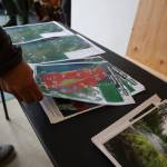 A residents grabs a print of the final Montana Creek master plan at a public meeting at the Trail Mix Inc. shop Wednesday evening. (Clarise Larson / Juneau Empire)