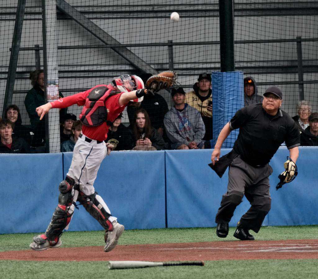 JDHS junior catcher Lamar Blatnick reaches for a foul ball as umpire Keith Perkins looks on during the Crimson Bears 9-1 loss to the Colony Knights on Thursday in the opening round of the ASAA Division I State Baseball Championships at Sitkas Moller Field. (Klas Stolpe / Juneau Empire)