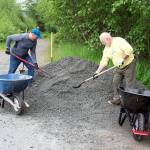 Mark Pusich, left, president of Trail Mix, and Ron Bressette, the non-profit groups vice president, shovel gravel into wheelbarrows so it can be spread on the Kingfisher Pond Loop Trail on Saturday. The gravel is a special type that expands and retains its shape during wet weather, thus preventing washouts. (Mark Sabatini / Juneau Empire)