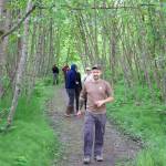 Ryan OShaughnessy, executive director of Trail Mix, and others helping the group improve the Kingfisher Pond Loop Trail on Saturday, head to the trailhead for a cookout lunch. (Mark Sabatini / Juneau Empire)