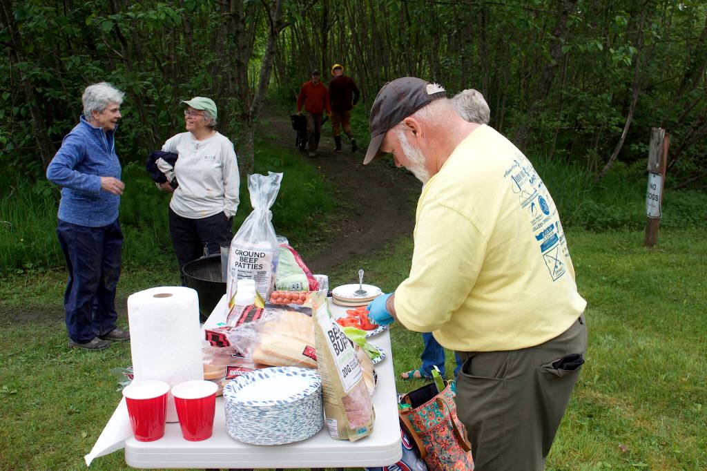 Trail Mix Vice President Ron Bressette prepares fixings for a cookout for workers who spent Saturday morning improving the Kingfisher Pond Loop Trail. (Mark Sabatini / Juneau Empire)