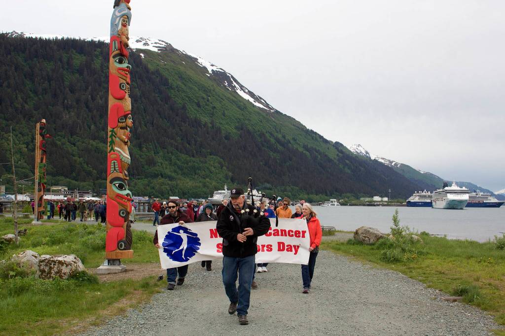 Rai Behnert plays the bagpipes as he leads about 50 people during the final stretch of Cancer Connections annual Celebration of Life Walk from Marine Park to Bill Overstreet Park on Sunday.