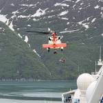 A passenger from the Sapphire Princess cruise ship is lifted into a rescue helicopter Monday in Glacier Bay at the same time the ship is involved with helping rescue passengers from a smaller cruise ship that caught fire during the morning. U.S. Coast Guard officials said the two incidents were not related. (Photo by Dan Reilly)
