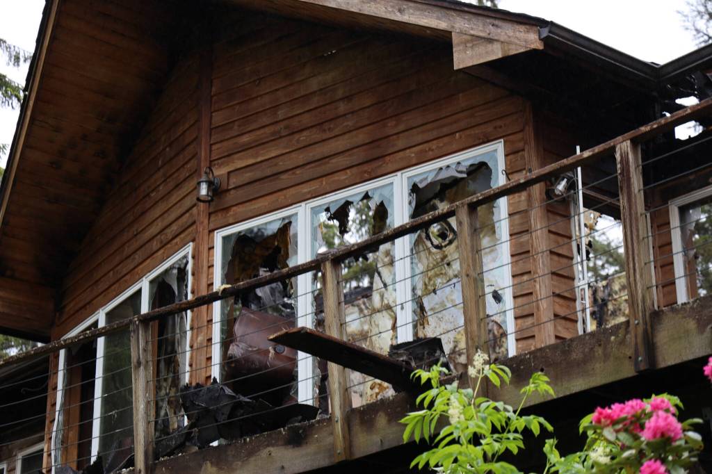 Broken windows and portions of the roof of a home in the Fritz Cove area near Fox Farm Trail are caved in following a structure fire Tuesday morning. No injuries were reported. (Clarise Larson / Juneau Empire)