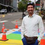 City and Borough of Juneau Assembly member Greg Smith smiles Thursday afternoon while walking across the rainbow crosswalk recently repainted in downtown Juneau. (Clarise Larson / Juneau Empire)
