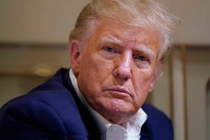 Former President Donald Trump listens as he speaks with reporters while in flight on his plane after a campaign rally at Waco Regional Airport, in Waco, Texas, on March 25 while en route to West Palm Beach, Fla. (AP Photo/Evan Vucci, File)