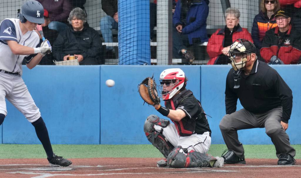 Home plate umpire Lawrence Woody Widmark watches a pitch as JDHS catcher Lamar Blatnick readies to receive the ball during the Alaska School Activities Association State Baseball Championships in Sitka last week. Widmark was honored with the ASAA Gold Lifetime Pass at the tournament. (Klas Stolpe / Juneau Empire)