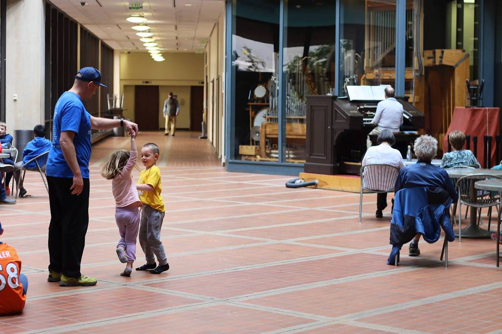 Jeff Layton, left, twirls his daughter Callie, 4, in a dance while his son Otto, 6, tries to cut in during the performance of the Annie showtune Tomorrow on Friday by J. Allan MacKinnon on the 1928 Kimball Theatre Pipe Organ in the Alaska State Office Building. The Layton family, visiting from Palmer, came to the building to hear the concerts a friend mentioned, not knowing it was the first such concert in more than three years due to the COVID-19 pandemic. (Mark Sabbatini / Juneau Empire)