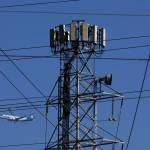 An Alaska Airlines plane flies by a cellular tower. (Photo by Justin Sullivan/Getty Images)